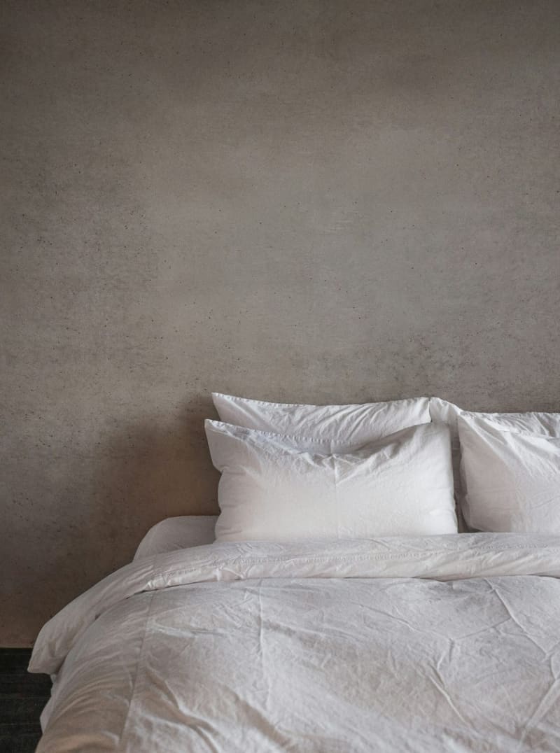 a made bed against a plain wall