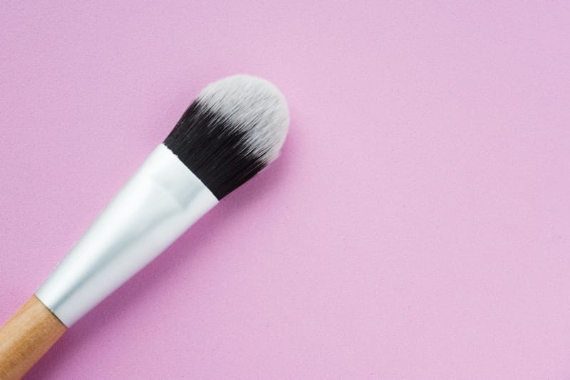 a make-up brush on pink