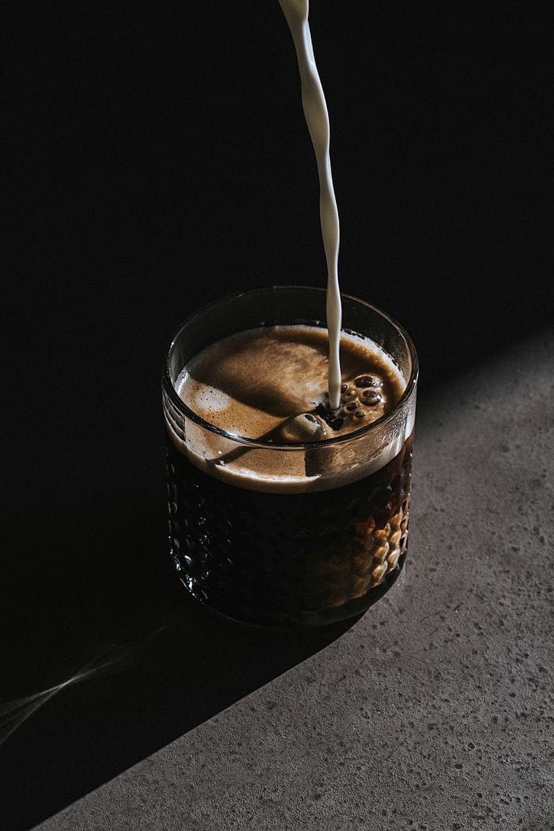 milk poured into an iced coffee glass
