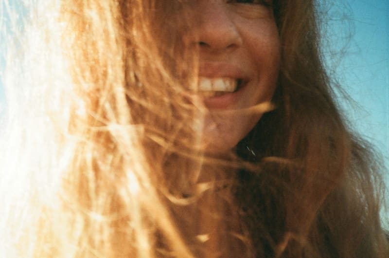 a woman laughing with hair across her face