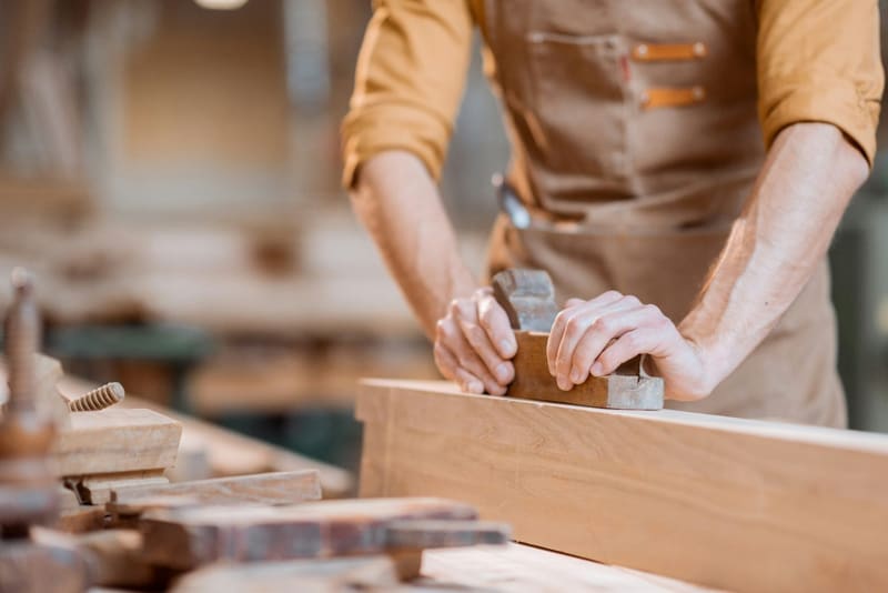a carpenter planing a board