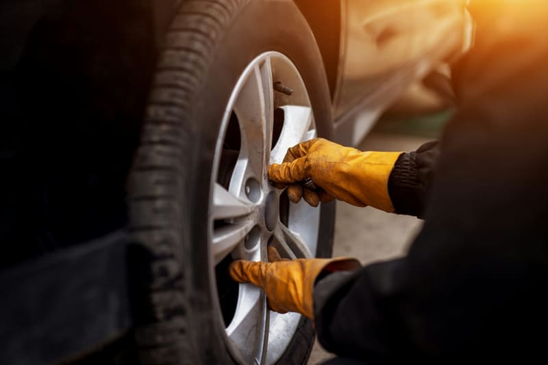 gloved hands changing a wheel