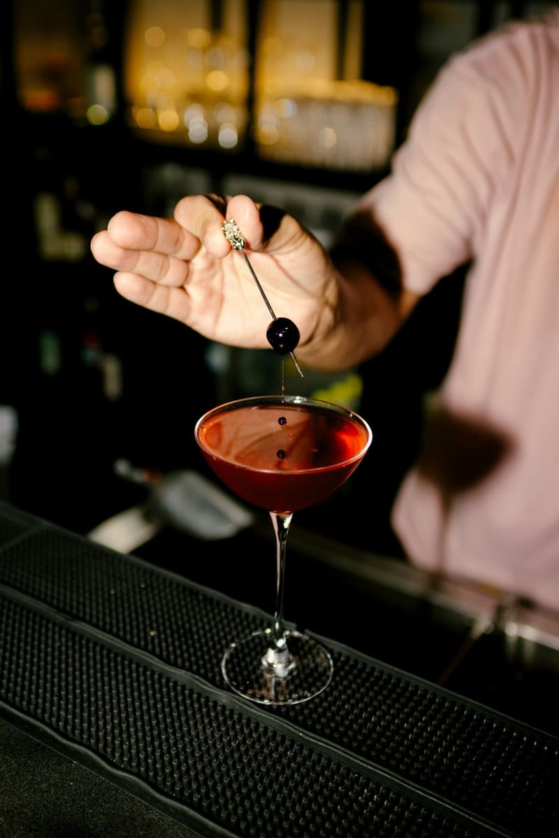 garnishing a manhattan with a cherry
