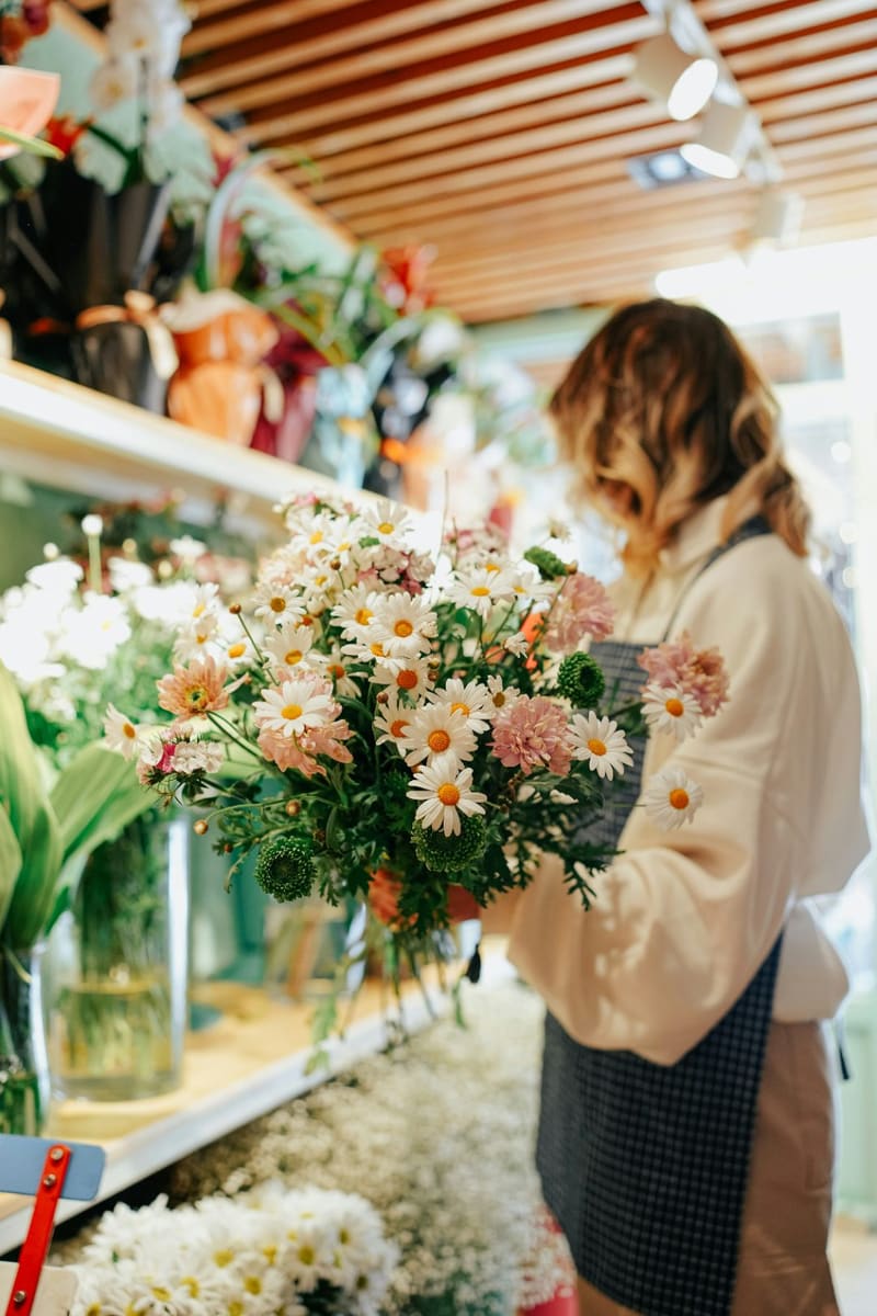 a florist holding a bunch of daisies
