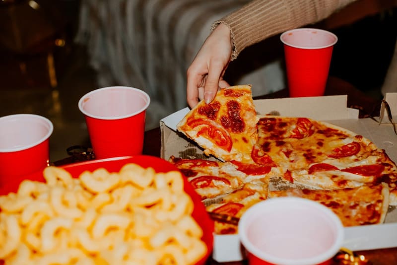 pizza and snacks in a box at a party