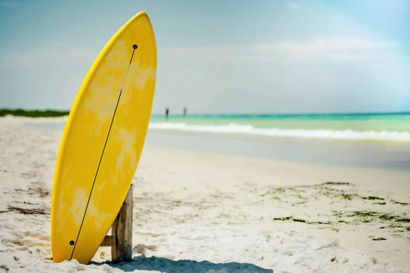 a yellow surfboard standing on sand