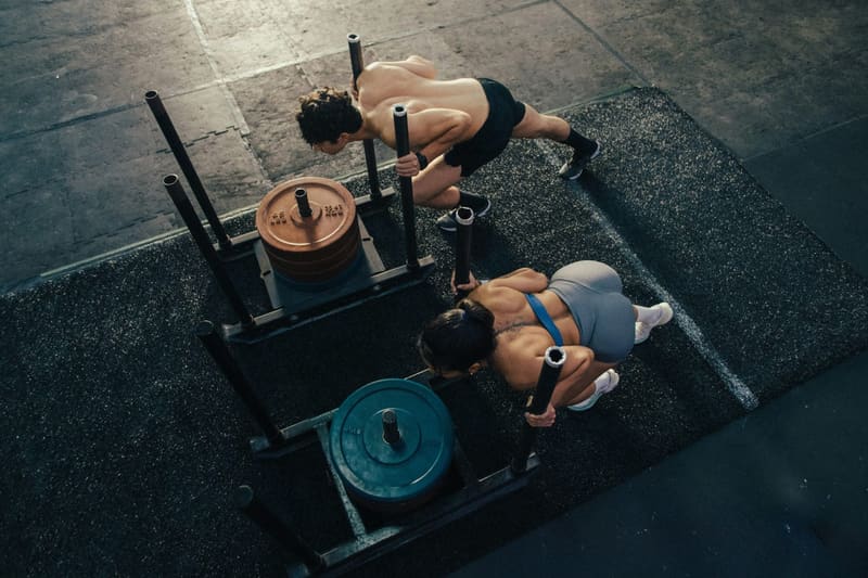 two people pushing a weight sled