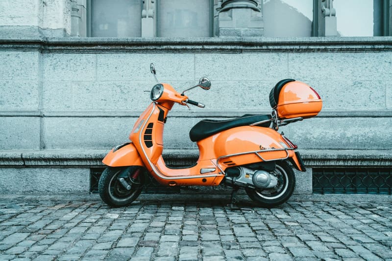 an orange scooter on cobbles