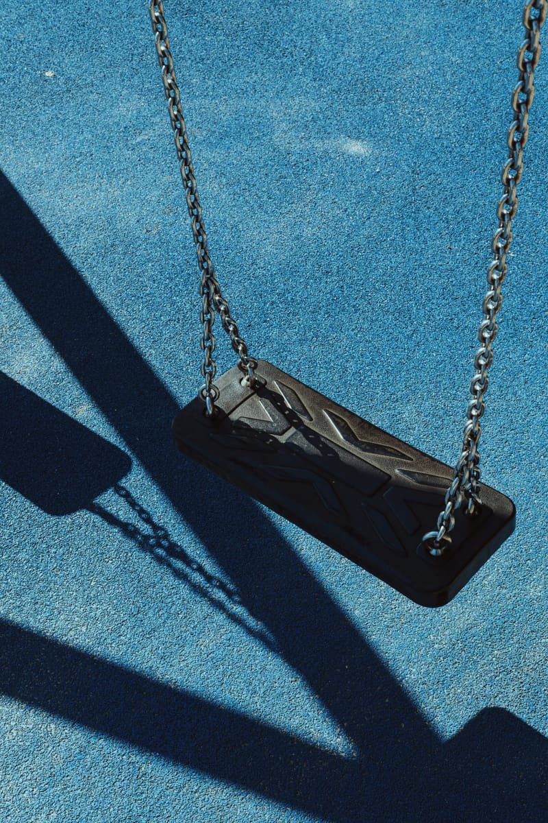 an empty swing on blue ground