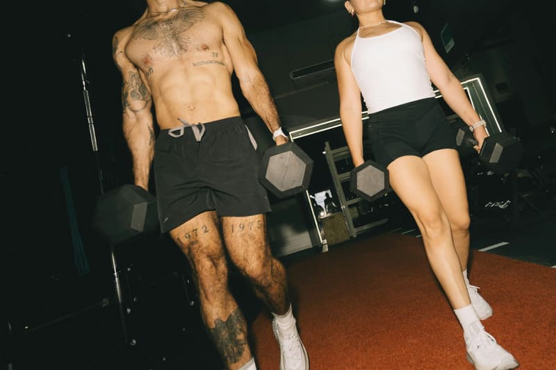 two people carrying dumbbells in a gym