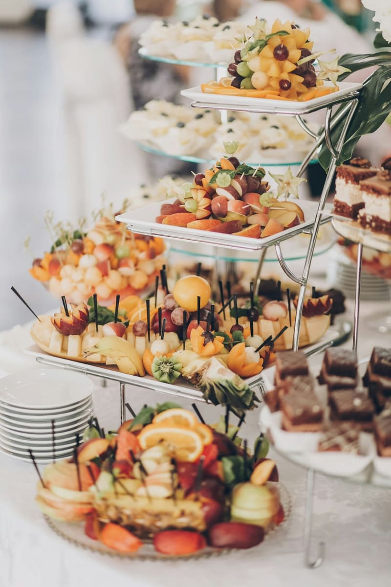 a tiered stand of canapes and cakes
