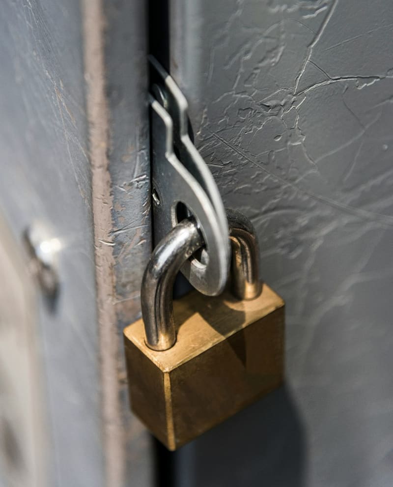 a brass padlock on a metal door
