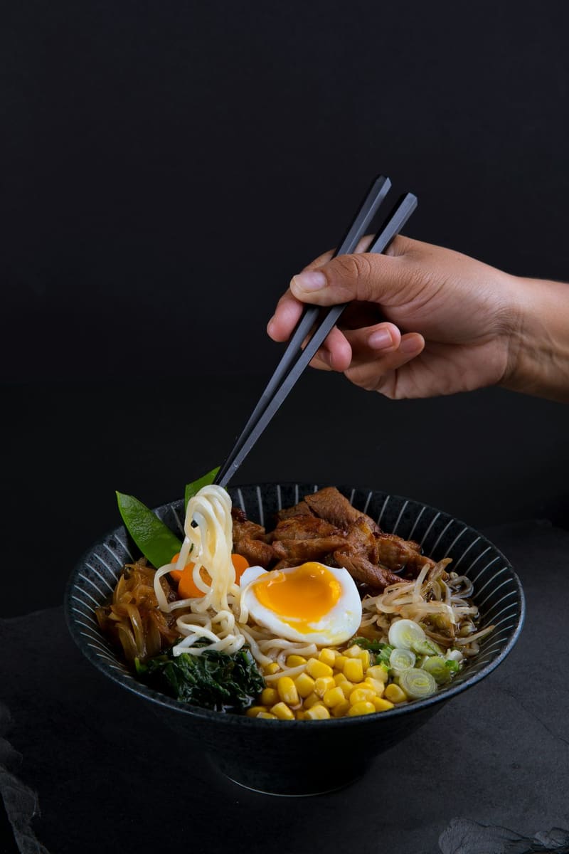 a bowl of ramen with chopsticks