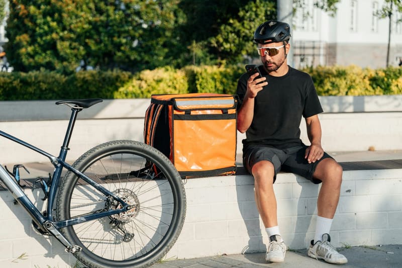 a courier sitting with a delivery bag