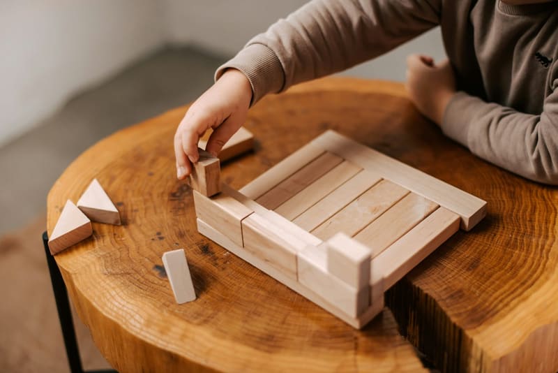 small hands stacking wooden blocks