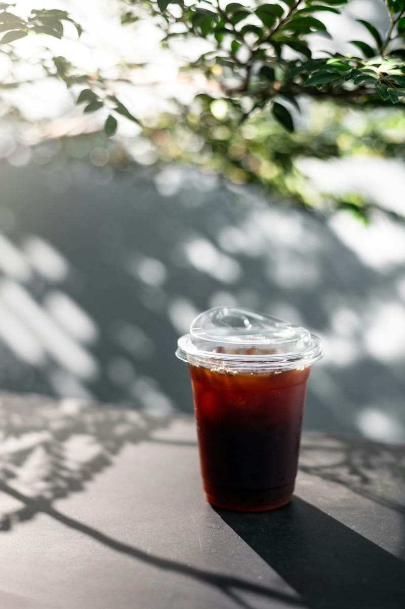 an iced coffee in dappled light