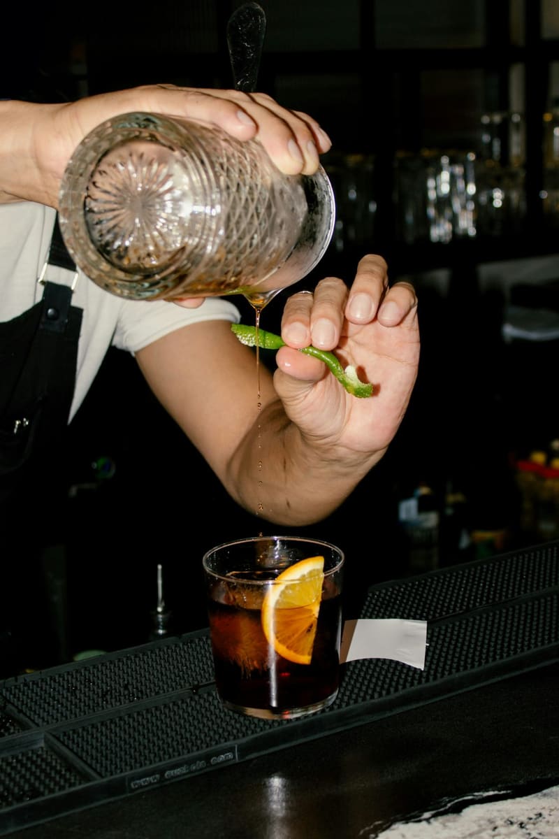pouring a cocktail over an orange slice