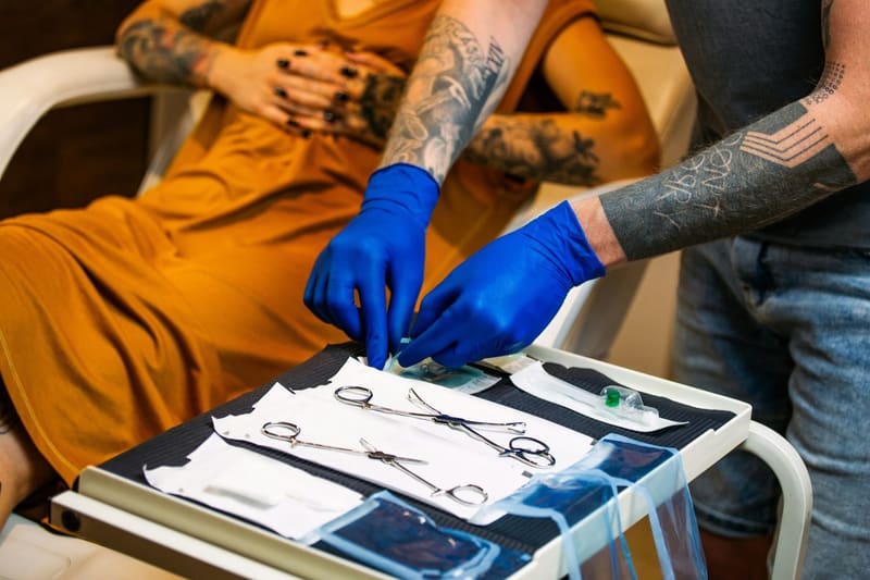 a piercing tray and gloved hands