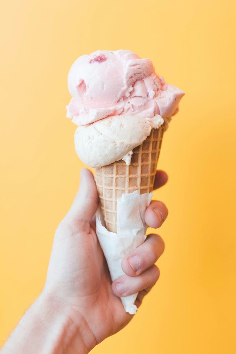 a hand holding an ice cream cone