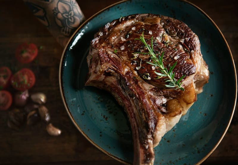 a cooked tomahawk steak on a plate