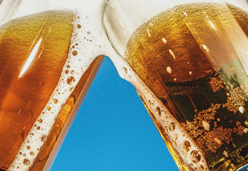 two beer glasses against a blue sky