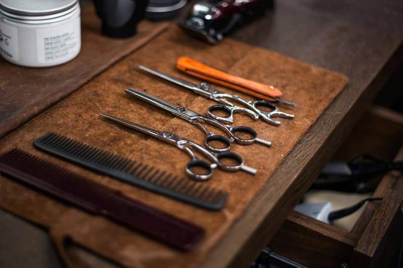 barber scissors and combs on wood