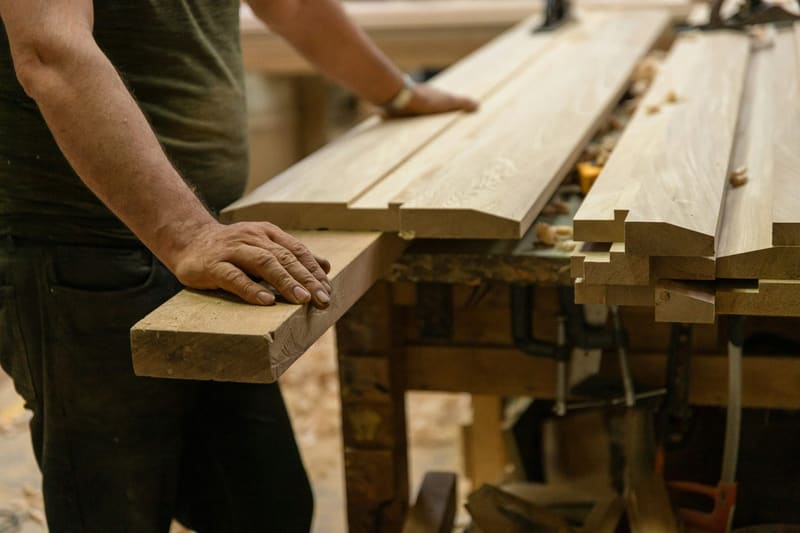 hands squaring planks on a bench