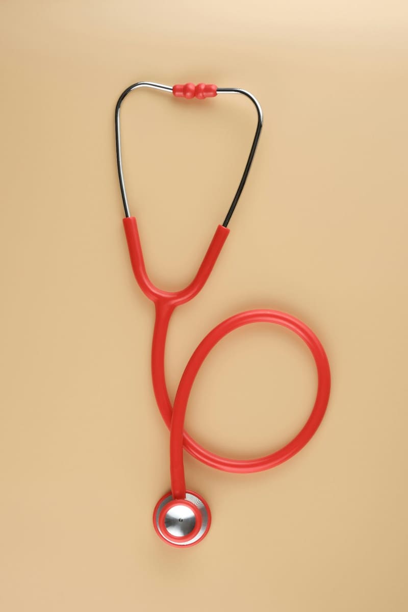 a red stethoscope on a beige ground