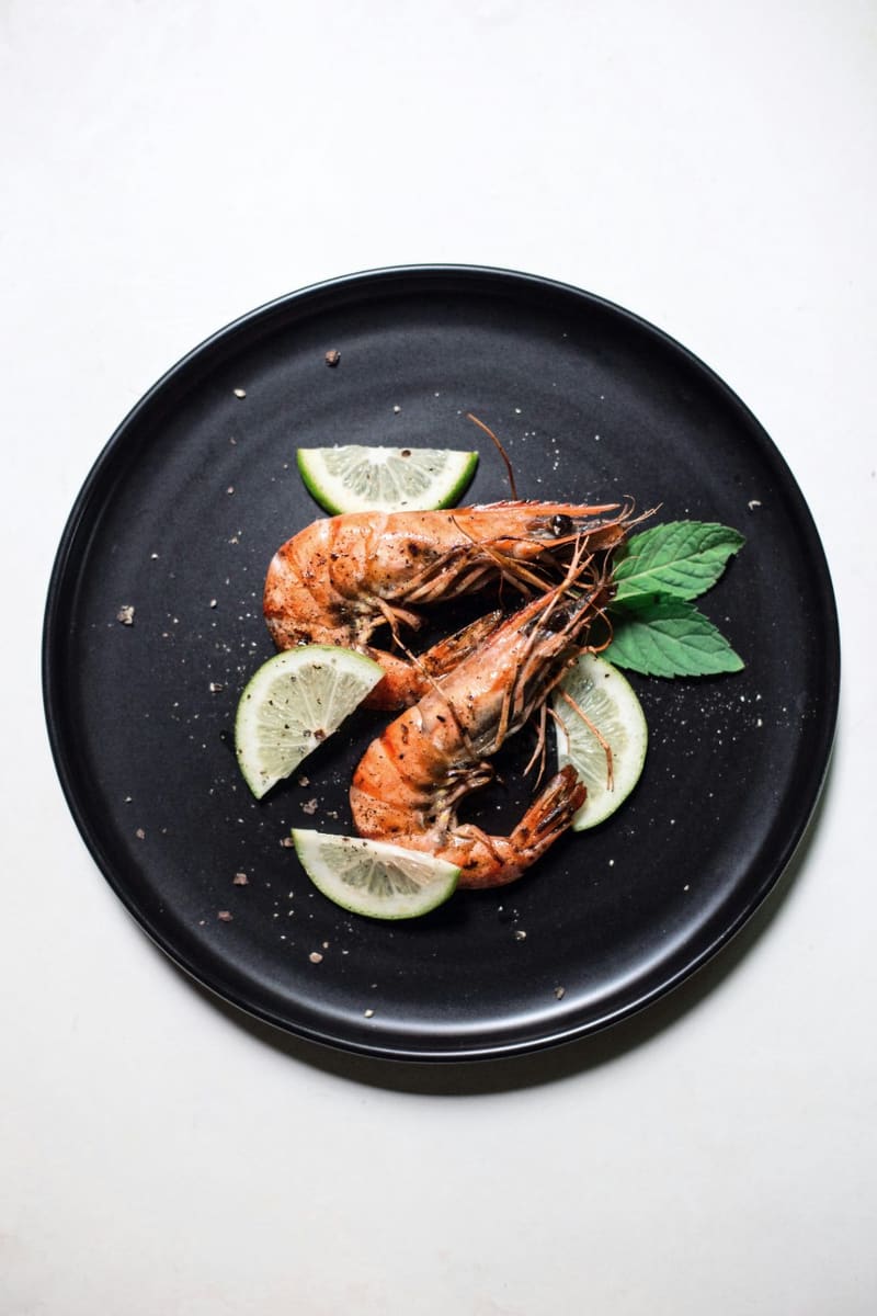 two prawns on a black plate
