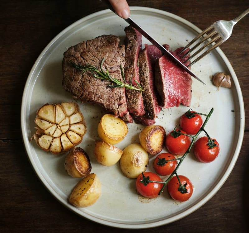 sliced steak with potatoes and tomatoes