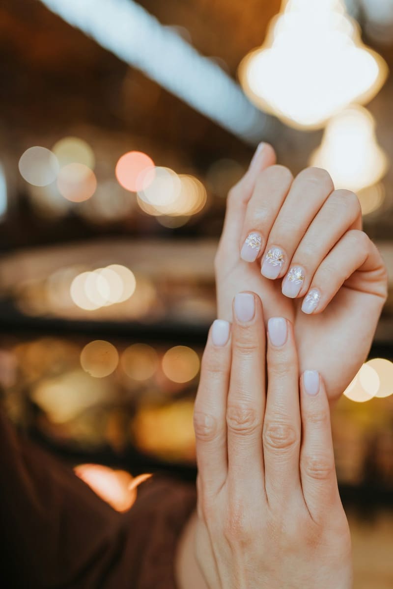 painted nails against bokeh lights