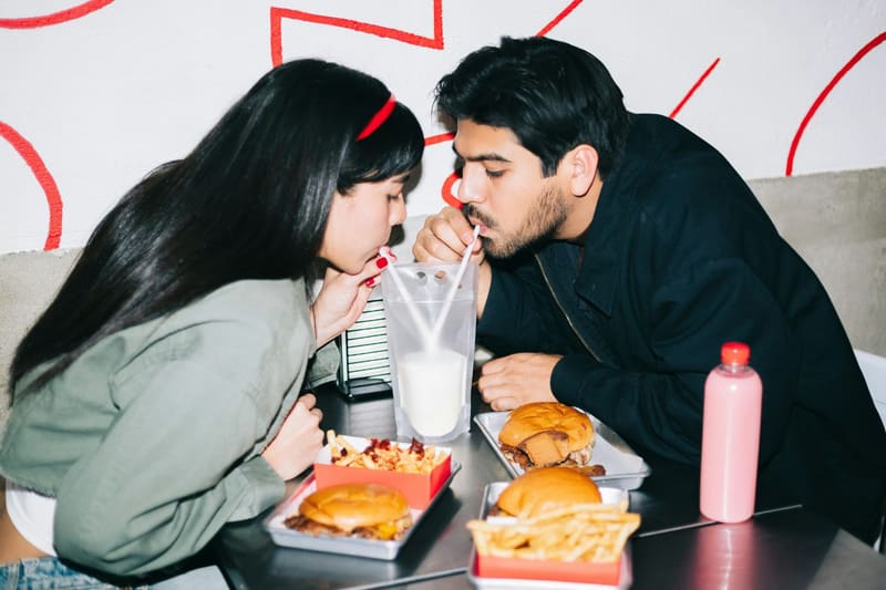 two people sharing burgers and shakes