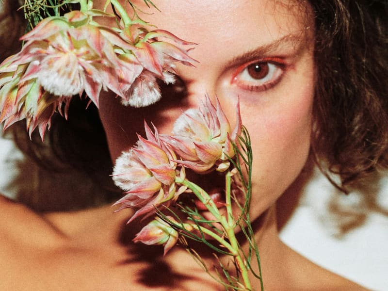 a face behind pale flowers