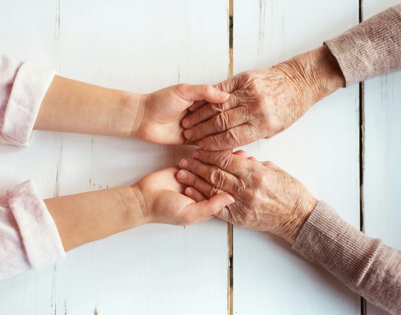 young hands holding older hands