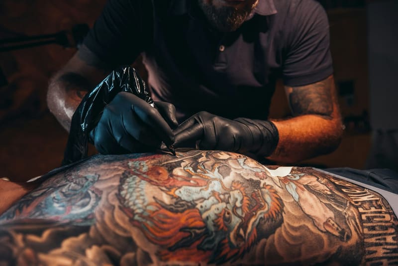 a tattooist working on a full sleeve