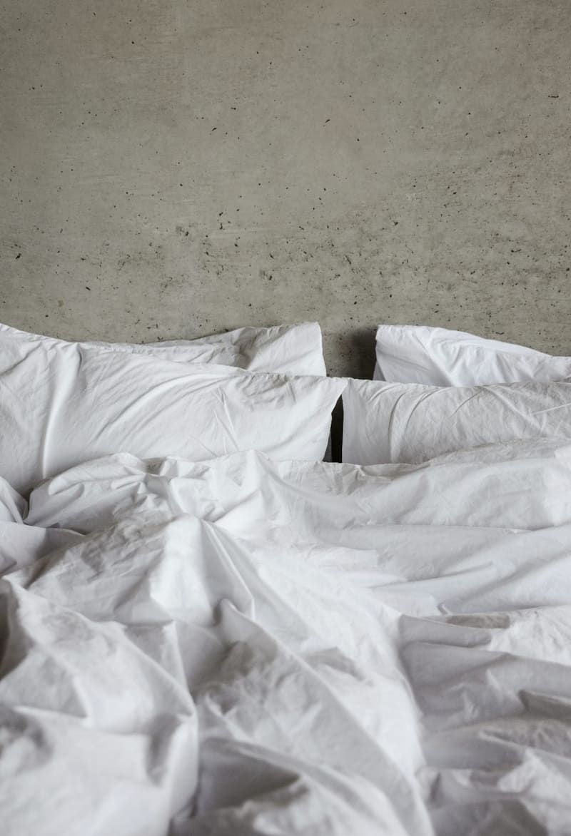 a rumpled white bed