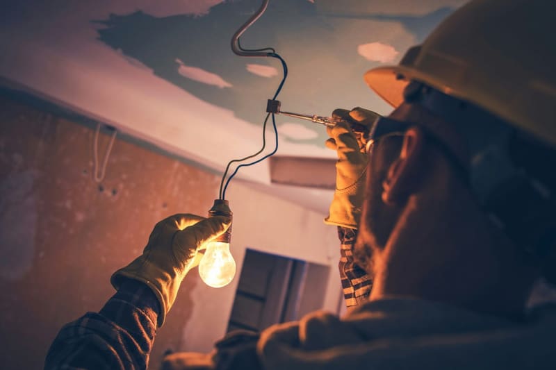 an electrician fitting a bulb outdoors