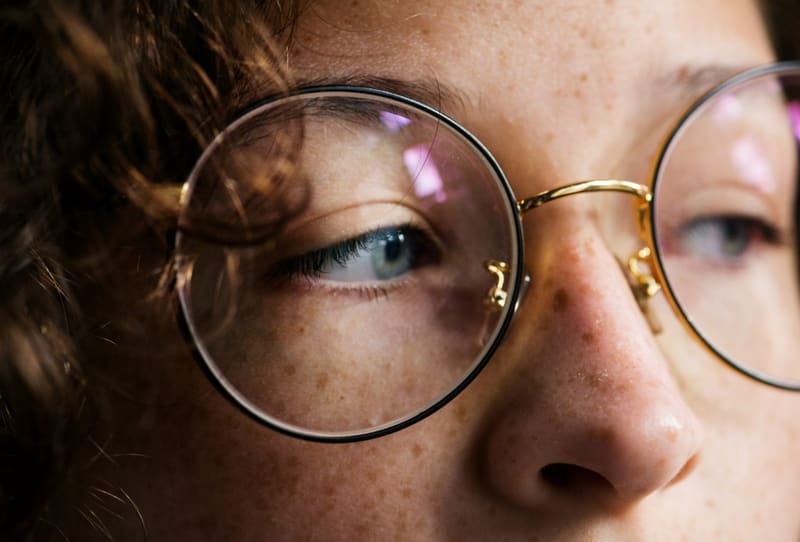 an eye behind a round spectacle lens