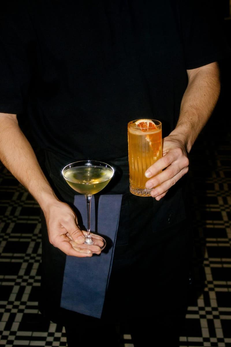 a waiter carrying two cocktails