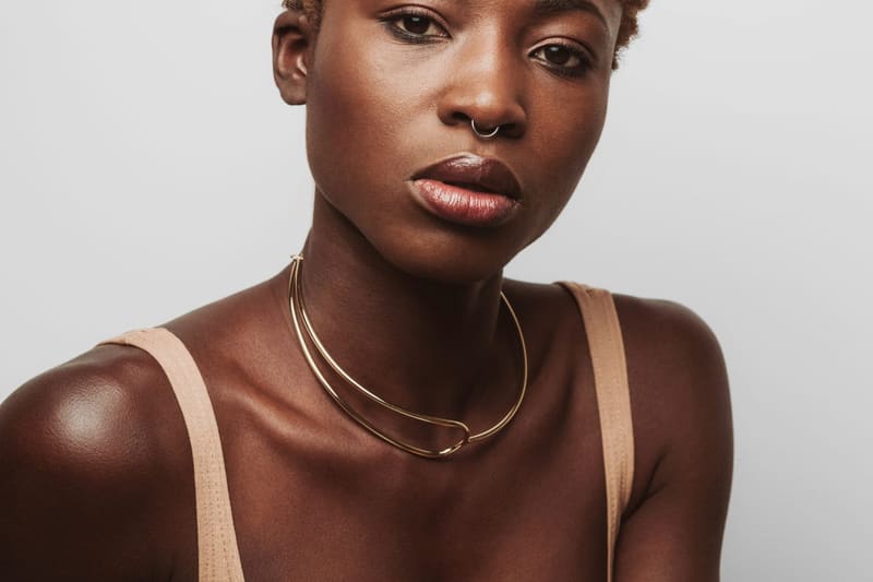 a woman wearing a gold collar necklace