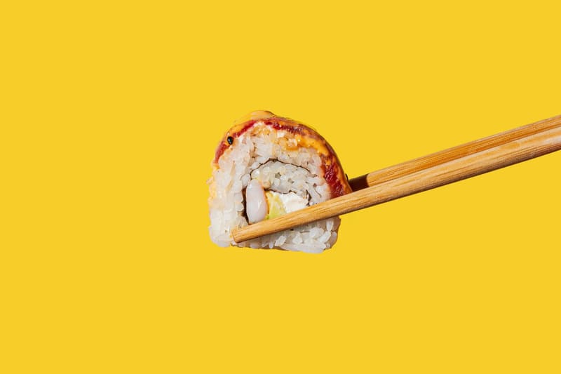 a sushi roll held in chopsticks