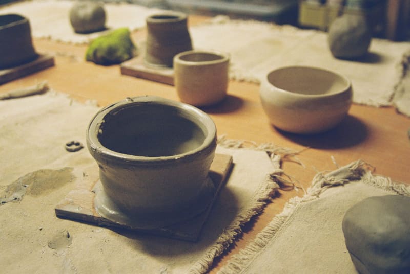 unfired clay pots on a bench