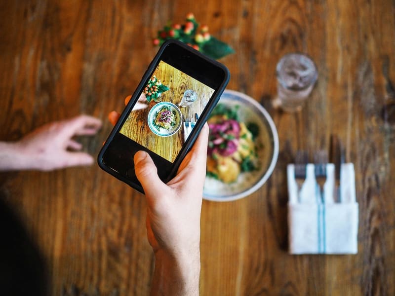 a phone photographing a bowl of food
