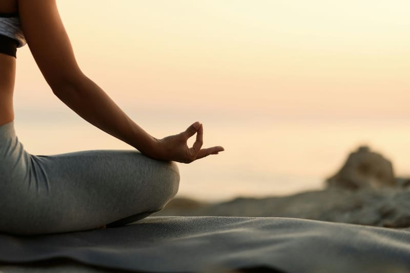 a hand in a mudra at sunrise