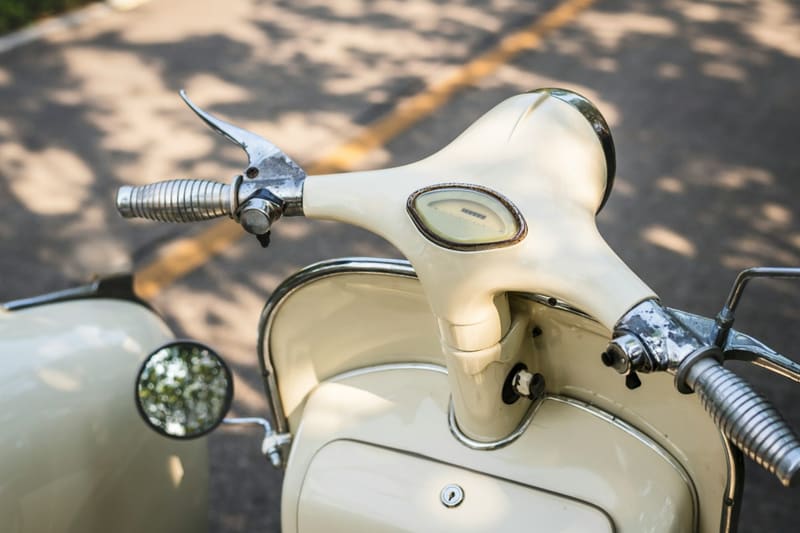 the handlebars of a cream scooter