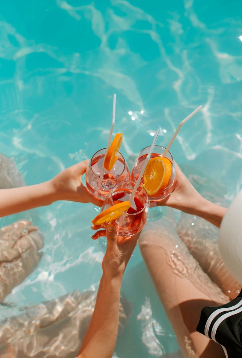 two spritz glasses over a pool
