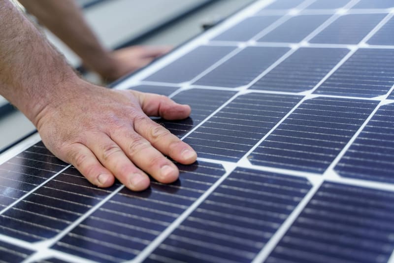 a hand on a solar panel