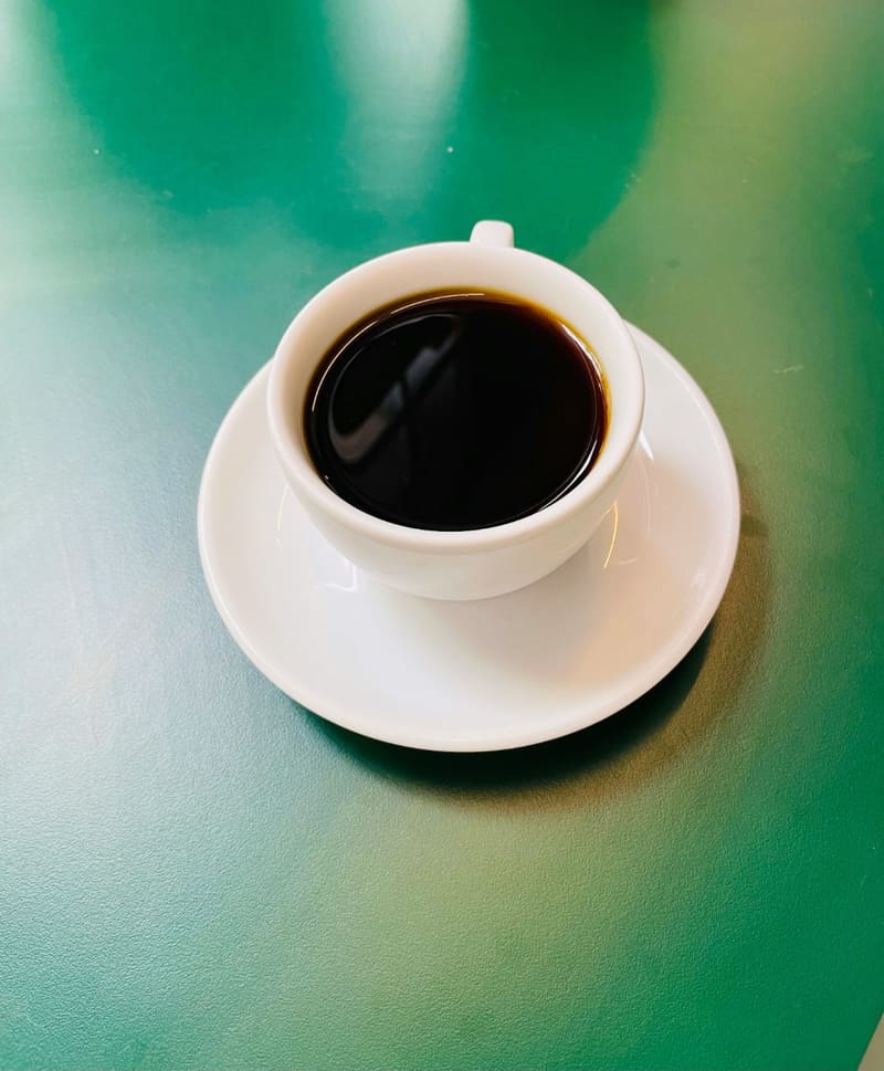 a black coffee on a green table