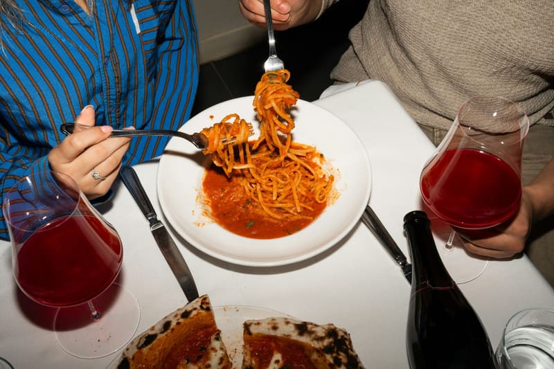 a forkful of spaghetti at a table