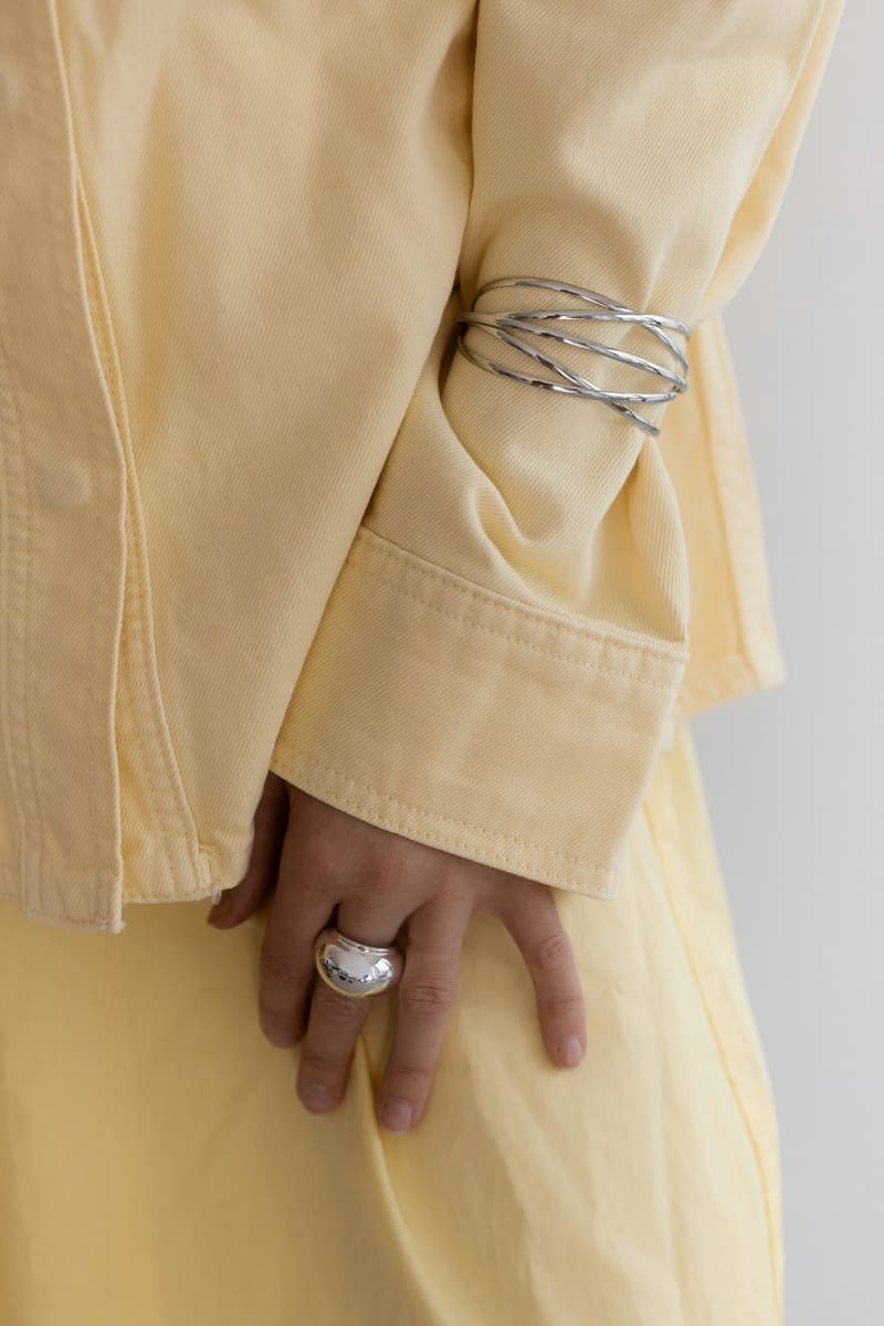 a hand with a silver ring and bangle
